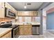 Bright kitchen features stainless steel appliances and ample cabinetry at 5208 Via Hacienda Cir # 201, Orlando, FL 32839