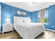 Bright bedroom with white bed, blue walls, and wood-look floors at 8881 Qin Loop, Kissimmee, FL 34747