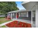 Front porch with red door and manicured landscaping at 1419 Ne 21St St, Ocala, FL 34470