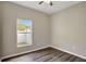 Bright bedroom with wood-look floors and a window offering backyard views at 2019 Wintermere Pointe Dr, Winter Garden, FL 34787