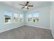 Bright bedroom with grey carpet, light blue walls, and multiple windows at 727 N Grandview Ave, Daytona Beach, FL 32118