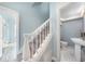 Stairway with white banister and carpeted steps, leading to a bathroom with marble tile at 727 N Grandview Ave, Daytona Beach, FL 32118