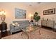 Living room with gray couch, dark hardwood floors, and a large painting at 1341 Arbor Vista Loop # 213, Lake Mary, FL 32746