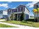 Two-story house with gray siding, red accents, and lake view at 1627 Pontiff Pl, Davenport, FL 33896