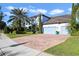 Two-story house with light-blue garage doors, brick driveway, and palm trees at 16659 Broadwater Ave, Winter Garden, FL 34787