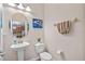 Clean powder room with pedestal sink, toilet, and circular mirror at 2081 Nerva Rd, Winter Garden, FL 34787