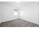 Simple bedroom with grey carpet, window with blinds, and white walls at 28054 Poppy Ct, Leesburg, FL 34748