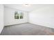 Bright bedroom with grey carpet and a large window at 28054 Poppy Ct, Leesburg, FL 34748