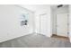 Bright bedroom with grey carpet, a window, and double door closet at 28054 Poppy Ct, Leesburg, FL 34748