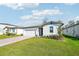 One-story house with light gray siding, white garage door, and a brick driveway at 28054 Poppy Ct, Leesburg, FL 34748