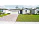 One-story home with gray exterior, two-car garage, and a paved driveway at 28054 Poppy Ct, Leesburg, FL 34748
