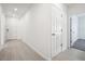 Interior hallway with light flooring, white walls, and doors to other rooms at 28054 Poppy Ct, Leesburg, FL 34748