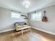 Cozy bedroom with wood floors, a yellow couch, and two large windows at 3701 Wyldwoode Ln, Orlando, FL 32806