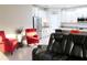 Spacious living room with red accent chairs and a black leather reclining sofa at 4420 Heritage Trl, Leesburg, FL 34748