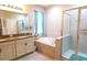 Main bathroom with a soaking tub, walk-in shower, and double vanity at 4420 Heritage Trl, Leesburg, FL 34748