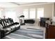 Relaxing living room with black leather couches, a home entertainment center, and an area rug at 4420 Heritage Trl, Leesburg, FL 34748