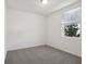 Spacious bedroom with gray carpeting and a window with blinds at 4706 Jasmine Cir, Leesburg, FL 34748