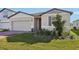 Single-story house with gray siding, brick accents, and a two-car garage at 4706 Jasmine Cir, Leesburg, FL 34748