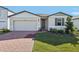 Single-story home with gray siding, brick accents, and a two-car garage at 4706 Jasmine Cir, Leesburg, FL 34748