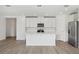 Open kitchen with white cabinets, center island, and stainless steel appliances at 4706 Jasmine Cir, Leesburg, FL 34748