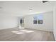Bright and spacious living room with wood-look flooring and large window at 4706 Jasmine Cir, Leesburg, FL 34748