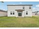 Two story house with backyard, grassy lawn, and covered patio at 4710 Jasmine Ct, Leesburg, FL 34748