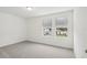 Bright bedroom with grey carpet and two windows at 4710 Jasmine Ct, Leesburg, FL 34748