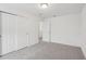 Spacious bedroom with grey carpet and double doors leading to another room at 4710 Jasmine Ct, Leesburg, FL 34748