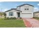 Two-story house with gray siding, teal shutters, and a brick driveway at 4710 Jasmine Ct, Leesburg, FL 34748