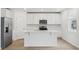 Modern kitchen with white cabinets, quartz island, and stainless steel appliances at 4710 Jasmine Ct, Leesburg, FL 34748