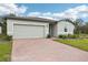 Gray house with a two-car garage and a brick paver driveway at 4736 Jasmine Cir, Leesburg, FL 34748