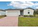 One-story home with gray siding, a two-car garage, and landscaped yard at 4736 Jasmine Cir, Leesburg, FL 34748