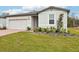 One-story house with gray siding, brick paver driveway, and well-manicured lawn at 4736 Jasmine Cir, Leesburg, FL 34748