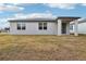 New construction home exterior showcasing a modern design and grassy backyard at 4736 Jasmine Cir, Leesburg, FL 34748