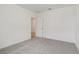Simple bedroom with grey carpet and door to another room at 4751 Jasmine Cir, Leesburg, FL 34748