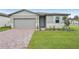 One story home with gray siding, light blue shutters, and a brick paver driveway at 4751 Jasmine Cir, Leesburg, FL 34748