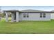 Gray house exterior with covered patio and grassy backyard at 4751 Jasmine Cir, Leesburg, FL 34748