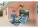 Relaxing patio with blue seating, ceiling fan, and sliding glass doors at 916 Reserve Pl, Davenport, FL 33896