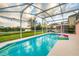 Inviting pool with a screened enclosure, overlooking a serene lake at sunset at 916 Reserve Pl, Davenport, FL 33896