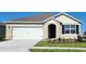 Tan one-story house with white garage door and blue shutters at 3827 Rory Pond Ct, Lakeland, FL 33811