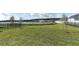 Spacious grassy backyard with a lake view and community in the distance at 7916 Waterfield Ave, Orlando, FL 32832