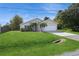 Tan house with white garage door, landscaping, and a spacious lawn at 8518 Rainbow Ave, Orlando, FL 32825