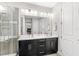 Modern bathroom with double vanities, dark cabinets, and a glass-enclosed shower at 14773 Crimson Bluff Aly, Winter Garden, FL 34787