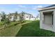 Large backyard with grassy area, trees, and covered patio at 6886 Wilson Hammock Ave, Groveland, FL 34736