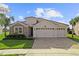 Beautiful two-story house with a three-car garage and stone accents at 1142 Trappers Trail Loop, Davenport, FL 33896