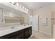 Modern bathroom with double vanity, large mirror, and shower at 1142 Trappers Trail Loop, Davenport, FL 33896