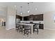 Open kitchen with dark cabinetry, island, and stainless steel appliances at 1142 Trappers Trail Loop, Davenport, FL 33896