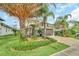 Landscaped front yard with tropical plants and a two-car garage at 2034 Sherbrook Ave, Davenport, FL 33837