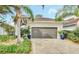 House exterior featuring a tile driveway, landscaping, and two-car garage at 2034 Sherbrook Ave, Davenport, FL 33837