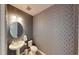 Stylish powder room with geometric patterned wallpaper and a pedestal sink at 2277 Derwent Dr, Davenport, FL 33896